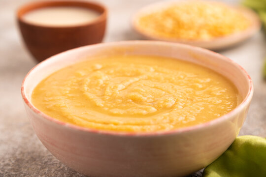 Pea cream soup, Puree, porridge in ceramic bowl on brown concrete, side view, close up, selective focus