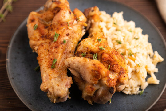 Fried Turkey Wing with spices and thyme on plate on brown wooden, side view, close up, selective focus