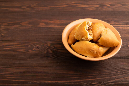 Homemade pies with jam and curd on brown wooden, copy space, side view