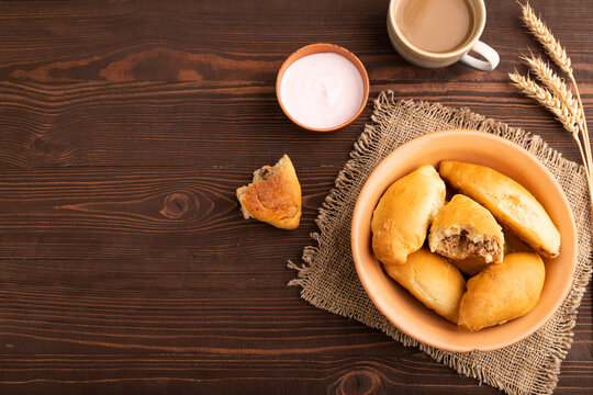 Homemade pies with jam and curd on brown wooden, copy space, top view