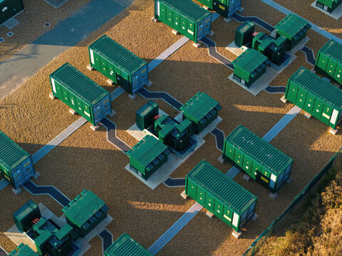 Aerial view of Battery Energy park, BESS Grendon, featuring rows of green energy storage containers and electrical infrastructure on a gravel site in Northampton, England, United Kingdom.
