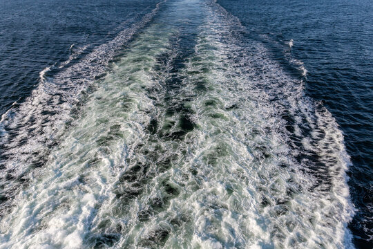 Wake from vessel on a sea surface at sunny morning