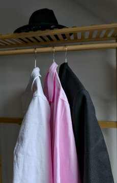 Organized wardrobe with hat on wooden shelf