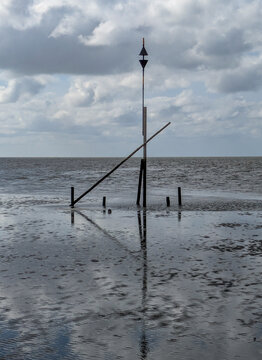 Gefahrenzeichen im Watt vor Cuxhaven-Sahlenburg. Es steht vor einem Priel&uuml;bergang, der bei Ebbe von Pferdekutschen benutzt wird
