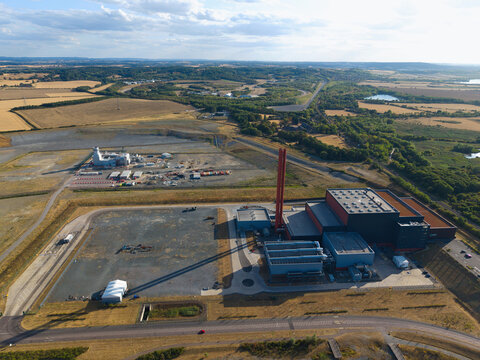 Aerial view of the Rookery South ERF and Millbrook power plant complex with its large chimneys and industrial buildings surrounded by open fields and roads in Stewartby, England, United Kingdom.