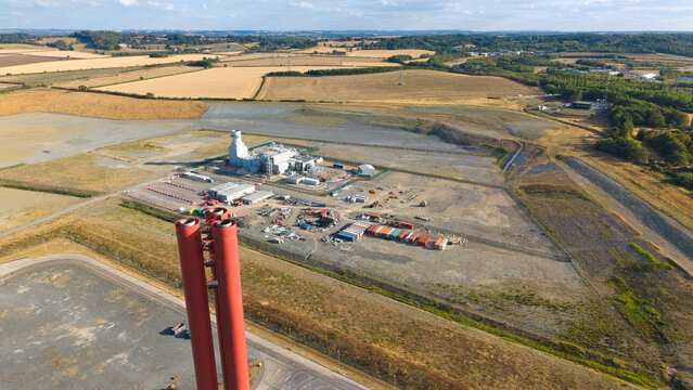 Aerial view of Millbrook Power Plant with its prominent red chimneys, industrial facilities, and surrounding rural landscape in Stewartby, England, United Kingdom.