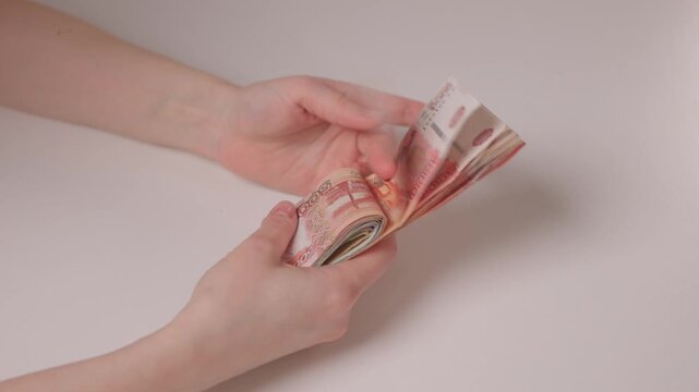 Small business owner expertly organizing mixed denomination banknotes on table. Detailed scene of entrepreneur counting and managing various colorful cash notes attentively