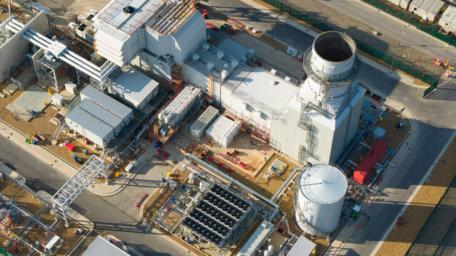 Aerial view of Millbrook Power Plant featuring industrial infrastructure, cooling systems, storage tanks, and surrounding paved areas in Stewartby, England, United Kingdom.