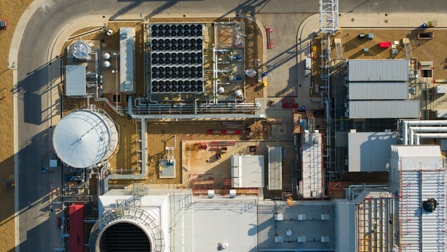 Aerial view of Millbrook Power Plant showing industrial infrastructure, cooling fans, storage tanks, and pipes in Stewartby, England, United Kingdom.