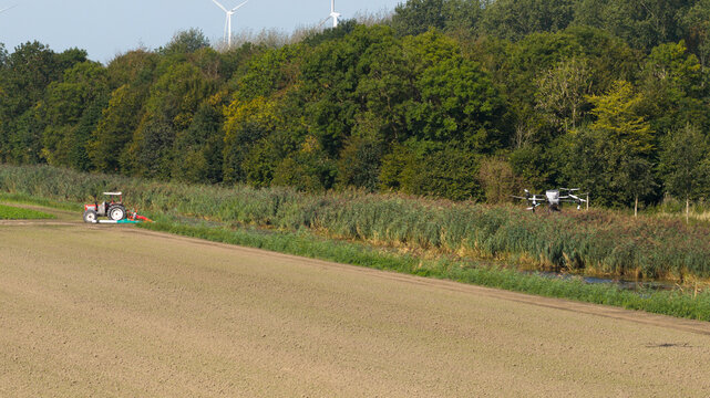 Aerial view of an agricultural UAV spraying and seeding crops, showcasing precision farming, automation, smart agriculture and modern crop management technology.