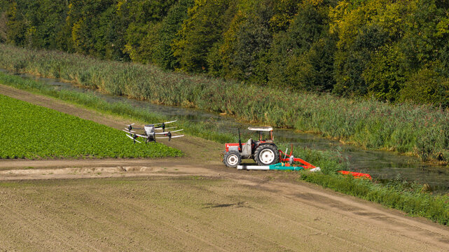 Aerial view of an agricultural UAV spraying and seeding crops, showcasing precision farming, automation, smart agriculture and modern crop management technology.