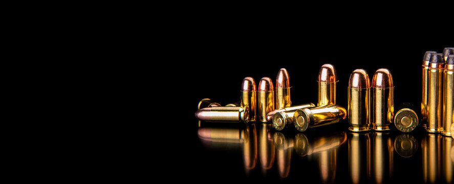 Handgun bullets arranged on reflective black back