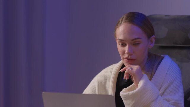 Female coder working. Female developer studying terminal output late at night. Dedicated woman engaged in remote software development and troubleshooting during nighttime hours