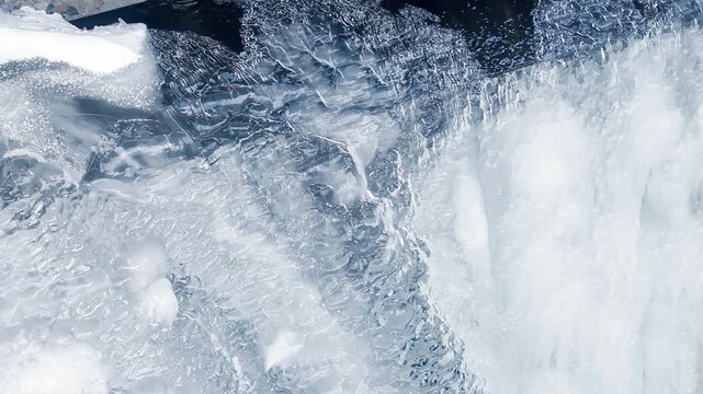 Closeup melting ice edge dark river water. Transparent ice sheet winter thaw.