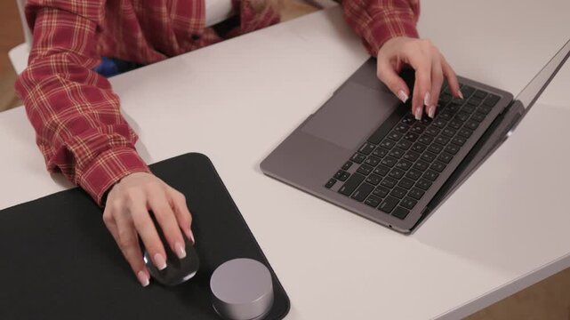 Young lady editing content from home. Female professional concentrating on digital editing task. Young woman in casual attire diligently working on her laptop at home