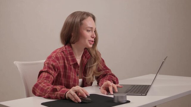 Young lady editing content from home. Female professional concentrating on digital editing task. Young woman in casual attire diligently working on her laptop at home