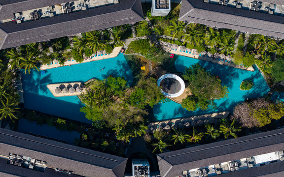 Aerial view of Marriott's Bali Nusa Dua Gardens featuring turquoise swimming pools surrounded by lush tropical gardens and resort buildings in Kecamatan Kuta Selatan, Bali, Indonesia.