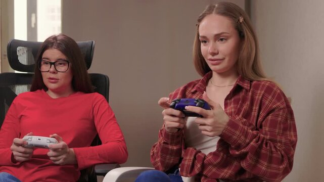 Women play games. Relaxed friends enjoying video games with cheerful interactions. Two women engage in friendly game night amid comfortable surroundings and joyful laughter