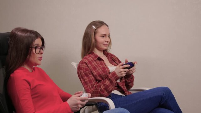 Women play games. Relaxed friends enjoying video games with cheerful interactions. Two women engage in friendly game night amid comfortable surroundings and joyful laughter