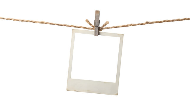Empty vintage photo frame hanging on a rope with a wooden clothespin isolated on transparent background