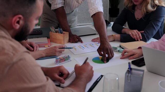 Multicultural business team discussing pie chart data