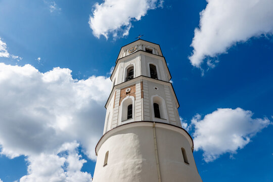 White historic Vilnius Cathedral bell tower rising against vivid blue sky, viewed from below. Vilnius old town in Lithuania