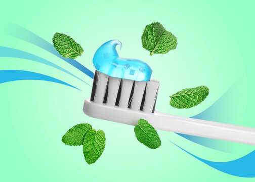 Toothbrush with toothpaste and flying mint leaves against aquamarine color background