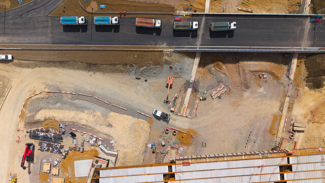Aerial view of the Black Cat Roundabout highway construction site featuring heavy machinery, trucks, and ongoing civil engineering works in Chawston, England, United Kingdom.
