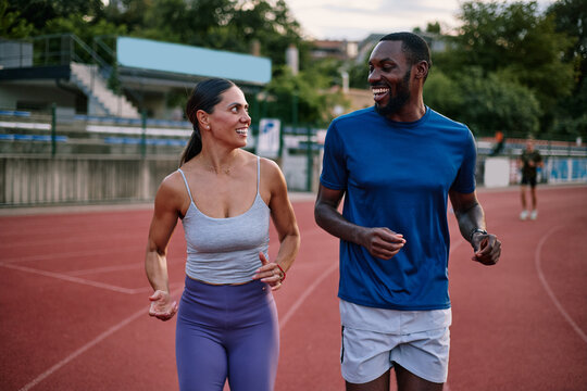 Diverse couple running together on stadium track