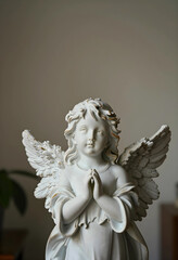 Obraz premium Spirituality and faith concept porcelain angel figurine with praying hands for religious peace hope and divine protection in a home interior settings