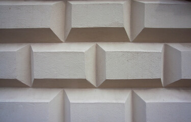 Biała ściana o oryginalnym wzorze - kostka, pudełka, prostokąty, wrażenie 3d. A white wall with a unique pattern—cubes, boxes, and a 3D effect. 
