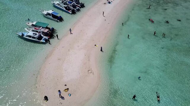High altitude drone video of Taka Makassar white sand shoal in clear blue ocean