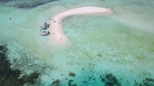Cinematic drone flyover of crescent shaped sandbar Taka Makassar in Flores Indonesia