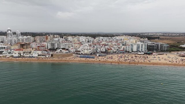 People sunbathing on armacao de pera beach, algarve portugal