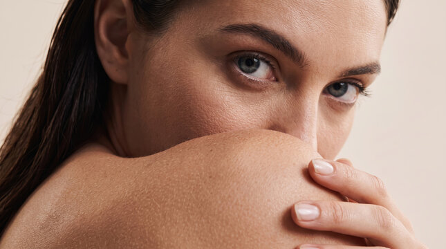 Woman looking over her shoulder with an intense gaze, highlighting natural beauty, clean skin, and wellness concepts suitable for skincare and cosmetic advertising