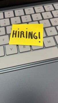 Hiring sticky note on laptop keyboard tech recruitment