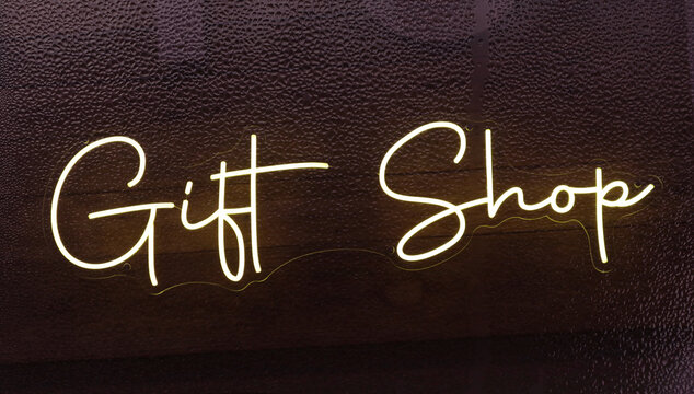 Modern Neon Sign in Wet Window of Gift Shop