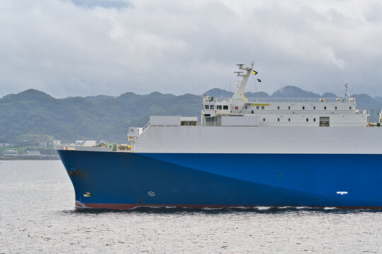Vehicle carrier RO-RO cargo ship underway at sea, bow section and forward hull under cloudy skies