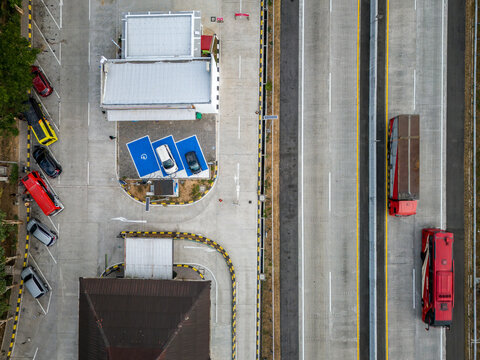 Aerial view of a highway rest area in Salatiga, featuring a parking spaces, electric vehicle charging stations, and buses along the toll road in Salatiga, Central Java, Indonesia.