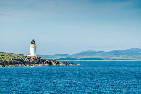 Phare de Lochindaal au bout de son promontoire, vu depuis la plage de Port Charlotte dans une lumi&egrave;re de fin de journ&eacute;e, &icirc;le d'Islay, Ecosse
