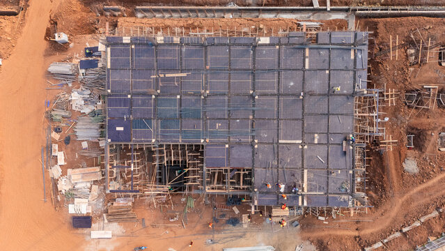 Aerial view of the Kawasan Industri Terpadu Batang construction site, showing the building foundation with rebar grids, formwork, and workers in Kecamatan Gringsing, Jawa Tengah, Indonesia.