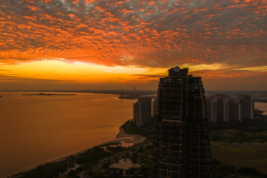 Aerial view of Forest City residential development at sunset with dramatic orange clouds over the coastal landscape in Gelang Patah, Johor Darul Ta'zim, Malaysia.