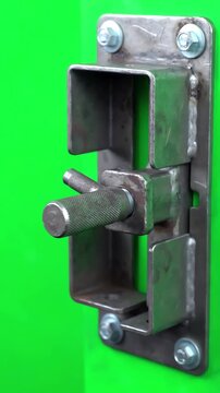 Heavy metal sliding bolt door latch locking and unlocking smoothly against a solid chroma key green screen background