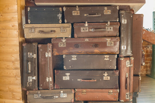 Stacked vintage suitcases fill a rustic wooden space