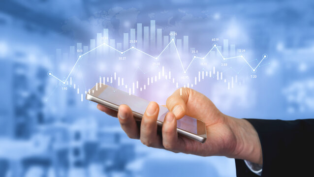 A businessman holds a smartphone displaying a digital graph, symbolizing financial data, stock market trends, and modern technology in a professional setting. Scalp
