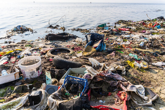 View of plastic waste, discarded tires, and debris scattered along the polluted shoreline of Lake Varna, Varna, Bulgaria.