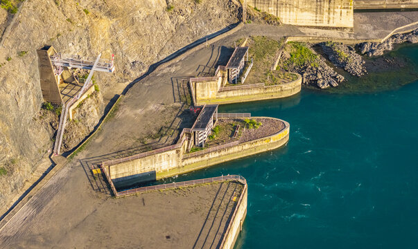 Aerial view of water intake and control structures beside a large hydroelectric dam reservoir in Rousset-Serre-Poncon, Provence-Alpes-Cote d'Azur, France.