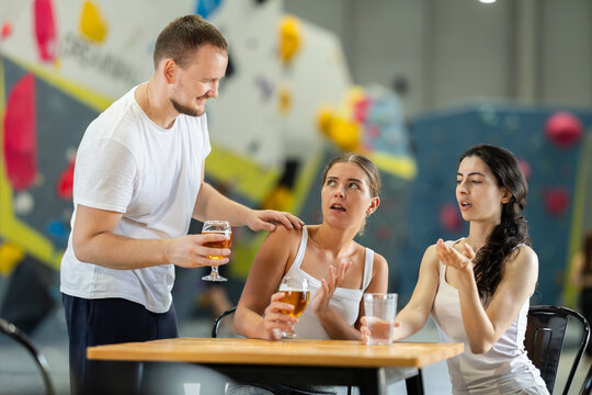 Man tries to pick up girls after rock climbing training. Girls refuse to talk to him. Man flirting with disappointed girls