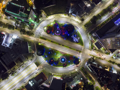 Aerial view of Glorieta Stampede at night, featuring illuminated sculptures, circular traffic patterns, and surrounding city lights in Guadalajara, Jalisco, Mexico.