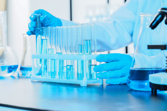 Medical research and pharmaceutical development, scientist working with test tubes and blue liquid in a laboratory for clinical testing and innovation